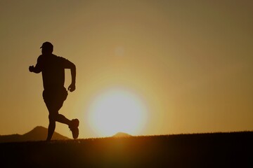 Fototapeta na wymiar Silhouette of a male runner at sunset