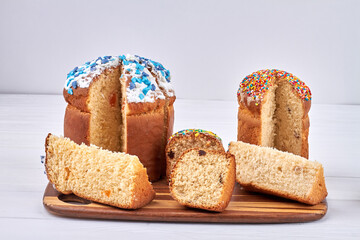 Sparkling coloured eggs and piece of tasty easter cake on white background.