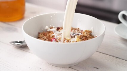 Pouring Milk into White Bowl Full of Crunchy Granola Cereals in Slow Motion (Phantom Flex) - Powered by Adobe