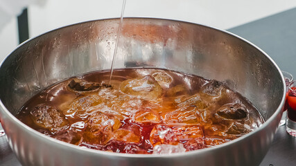 Mixed punch with fresh fruits in metal bowl
