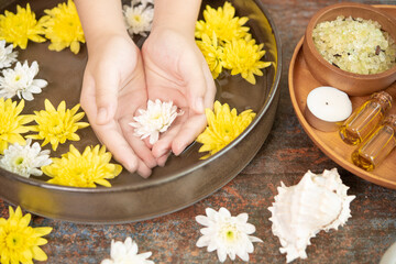 Obraz na płótnie Canvas Female hands and bowl of spa water with flowers, close up. Hands Spa.Manicure concept.