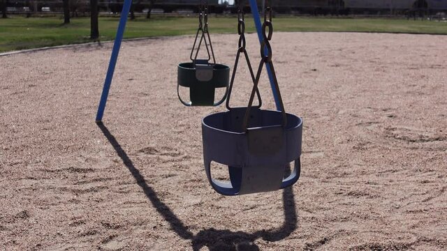 A close view of empty swings in the playground; child abduction