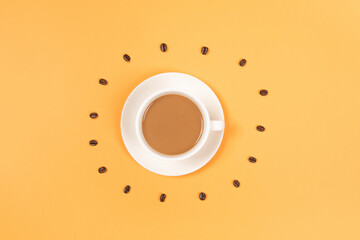 Circle from roasted coffee beans and coffee cup on yellow background