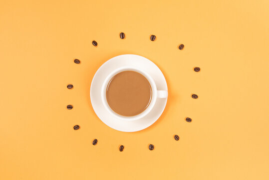 Circle from roasted coffee beans and coffee cup on yellow background © zhikun sun