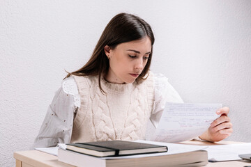 Young woman reading notes while studying at home. Study concept. Young woman.