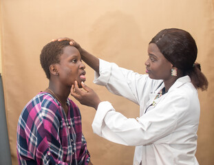 African female nurse , doctor or medical specialist checking a lady patient for health reasons, and also has stethoscope with her 
