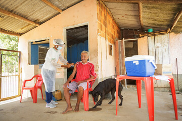 Nurse applies a second dose of vaccine against Covid 19 to an elderly man in a neighborhood on the...