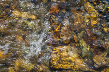 Natural background, the stones at the bottom of the creek. Clean stream.
