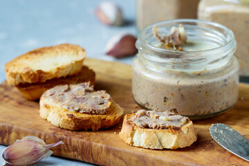 Sandwiches with homemade chicken liver pate  on a cutting board.
