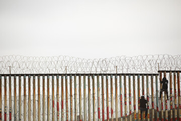 A moody overcast sky provides a backdrop for the USA and Mexico border wall in Tijuana, Mexico.