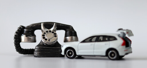 Miniature phones and broken white miniature cars. The concept of traffic accident reception.
