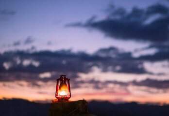 kerosene lamp lit with the sunset sky with the sky just after sunset in the. Concept of faith, religion and hope.