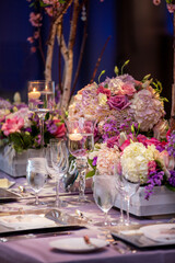 Indoor dinner setting for a wedding ceremony event with flowers and candles