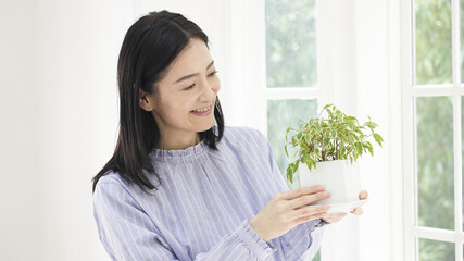家で観葉植物を育てるミドル女性