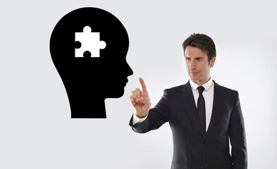 Man drawing Human head and jigsaw puzzle piece on a transparent board