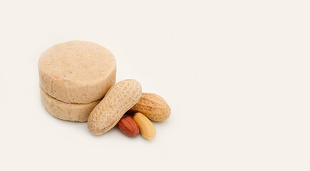 peeled and unpeeled peanuts next to marzipan candy  with copy space