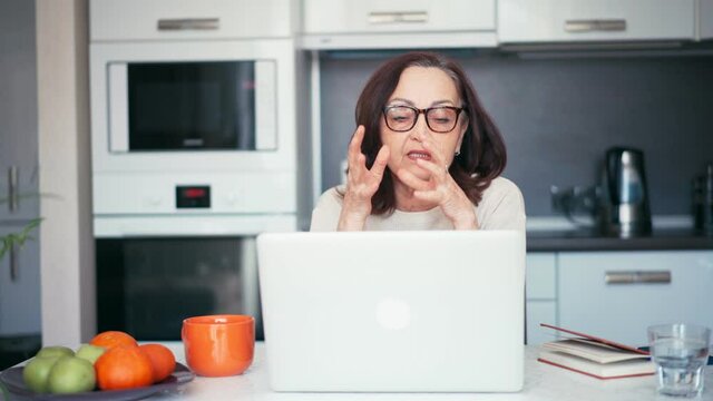 Senior mature older woman making a business training, online webinar on a laptop computer remote working. 60s businesswoman video conference calling in virtual chat.