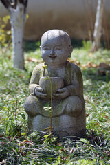 Fototapeta na wymiar Stone statue in the gardens of a Buddhist temple 