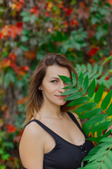 Fototapeta premium Beautiful portrait of a young woman in autumn bushes.