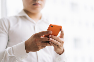 Asian businessman using smartphone by the window