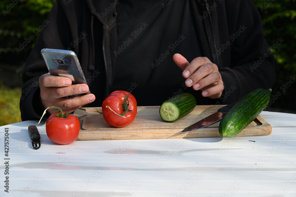 Canvas Prints Man looking at his phone and peeling cucumber