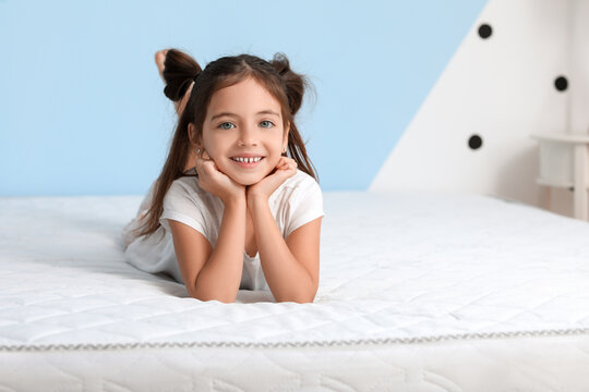Morning of little girl lying on bed with comfortable mattress