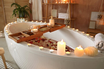 Interior of modern bathroom with burning candles in evening