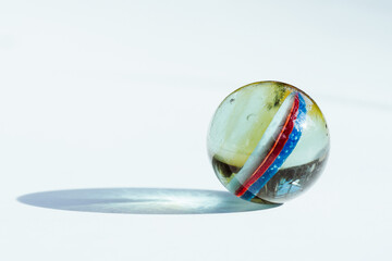 close up of multi colored glass marble on white background