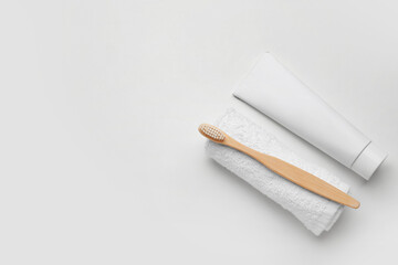 Tooth brush with paste and towel on white background