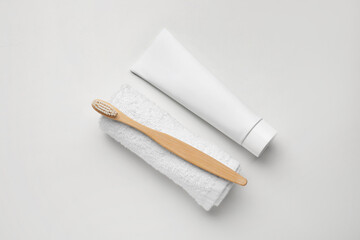 Tooth brush with paste and towel on white background