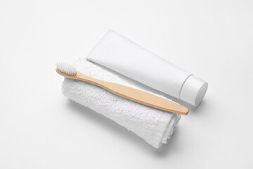 Tooth brush with paste and towel on white background
