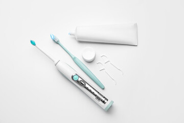Different tooth brushes and paste on white background