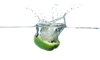 Falling of fresh cut bell pepper into water against white background