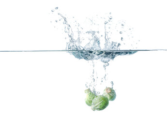 Falling of fresh Brussels sprouts into water against white background