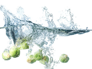 Falling of fresh Brussels sprouts into water against white background