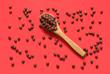 Spoon with chocolate corn balls on color background