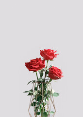 A bouquet of fresh red roses is in a metal vase. Floral holiday layout. Copy space.