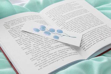 Book with bookmark on color background, closeup