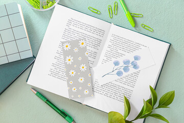 Book with bookmarks and stationery on color background