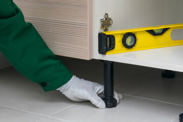 close-up of adjusting the correct installation of the cabinet, kitchen furniture