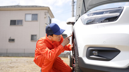 自動車のタイヤを点検する男性整備員