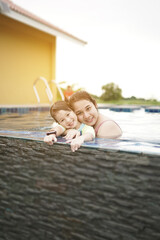 happy family asian mother with daughter play pool on leisure summer vacation