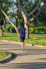 Vertical photo of Asian man jogging in the park