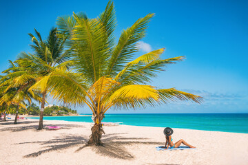 Caribbean travel summer vacation woman sunbathing on beach during cruise holiday. Luxury getaway on Dover Beach resort, Barbados island.