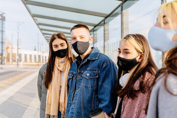 Urban public transport, city passengers transportation infrastructure with female and male passengers. City citizens or tourists in facial masks standing while waiting bus on bus stop.