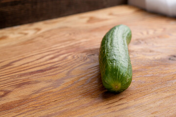 green cucumber on the wooden surface of the table