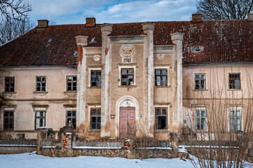 Entranceway to the Skede Manor with closed door. View of abandoned manor. Latvia.