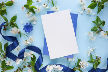 spring greeting card mockup. blooming cherry branches, envelope and white blank for text 