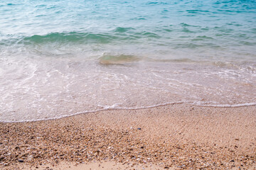 Sand beach with white sea soft wave on top view for assembling an article about travel in summer holiday or ocean coast nature.