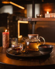 Tea brewing process, tea ceremony, freshly brewed green tea cup, warm soft light, dark background.
